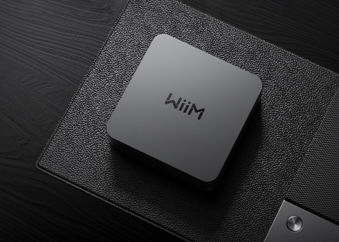 WiiM compact music streamer on dark surface